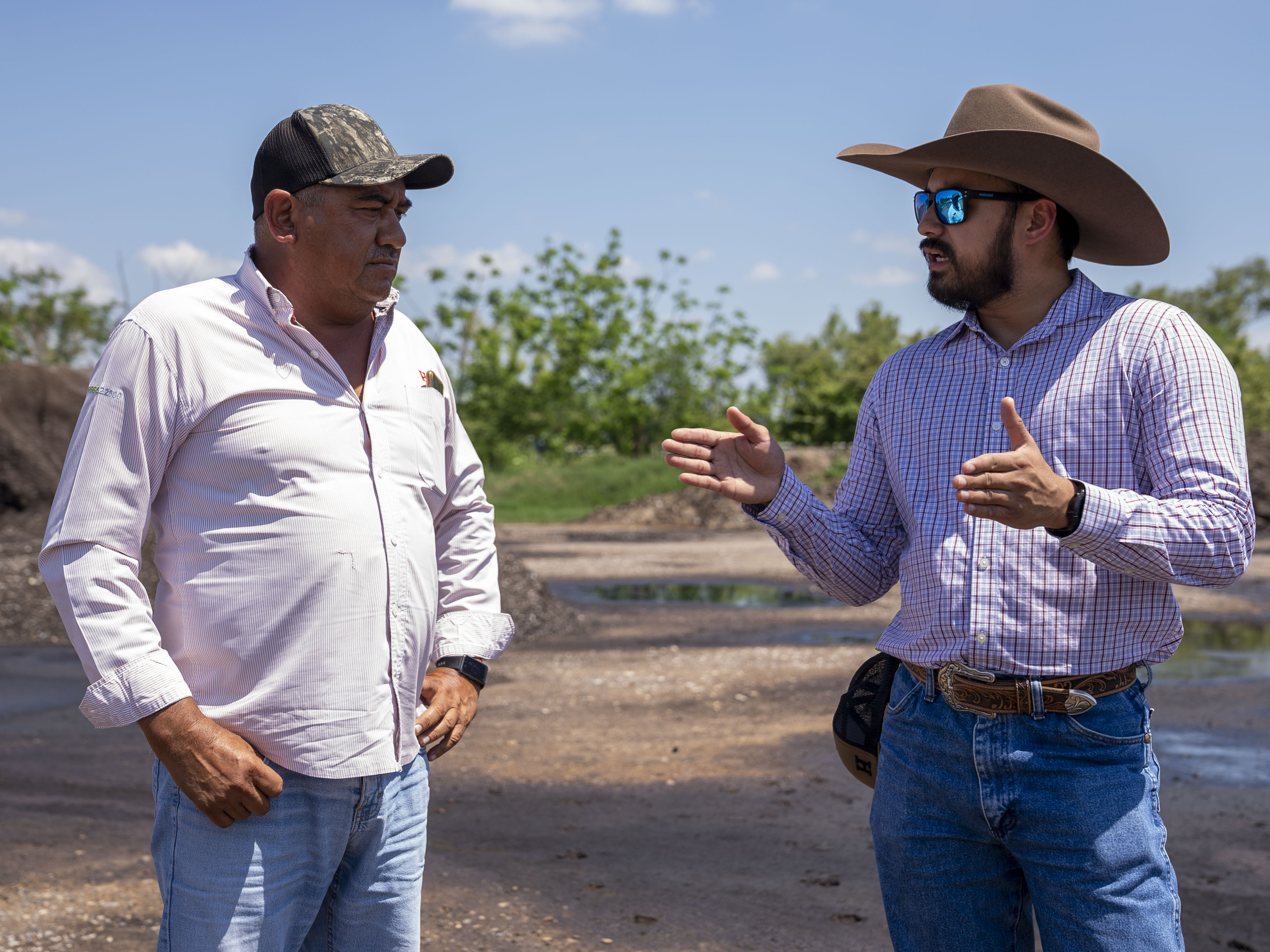 Two men talking to each other out in the field